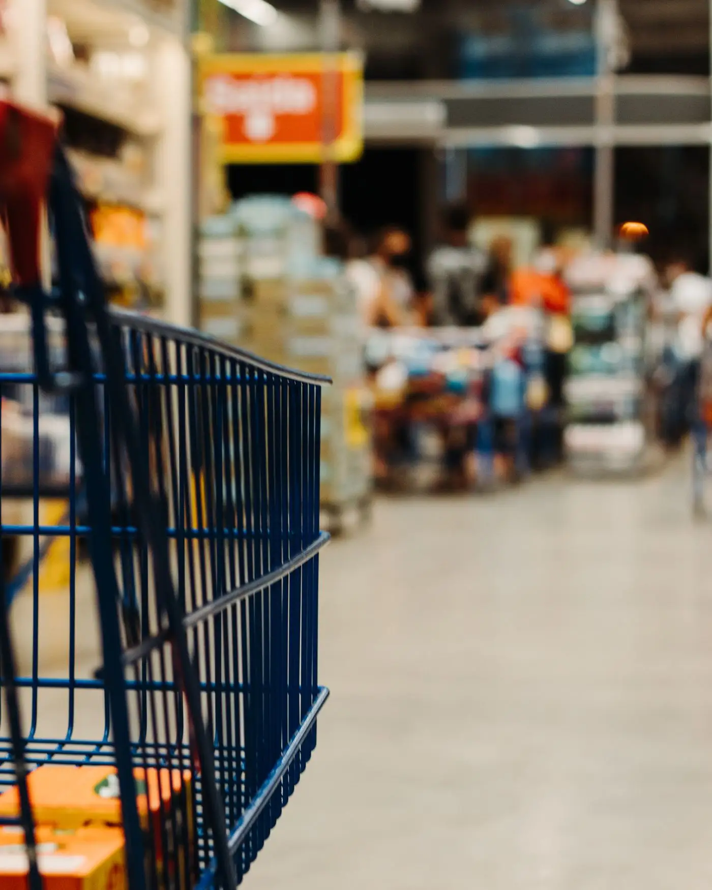 Shopping cart in a bright supermarket aisle